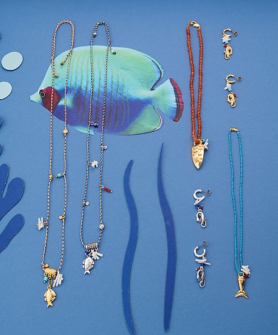Ocean-inspired jewelry with fish charms, sea-creature pendants and summer necklace designs on blue background